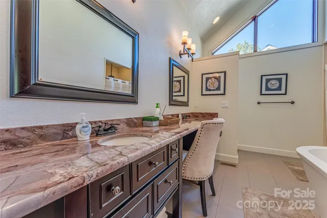 a bathroom with a granite countertop sink a mirror and a toilet