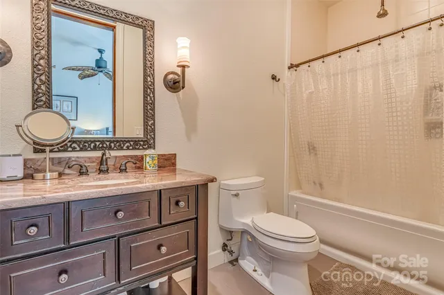 a bathroom with a granite countertop toilet sink and a mirror