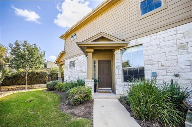 Doorway to property with stone siding and a yard