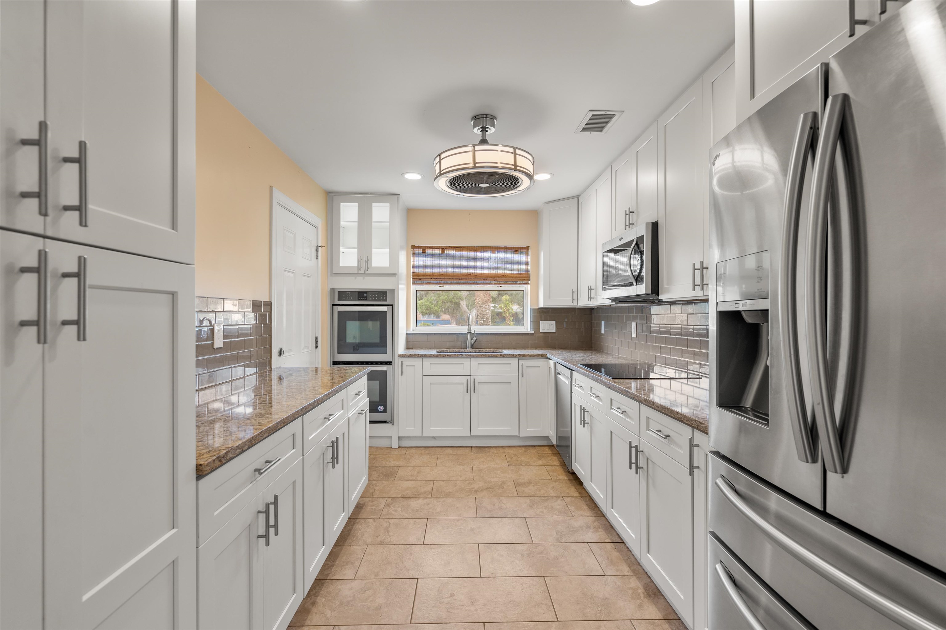 146 Menendez Road St. Augustine, FL 32080 - Photo 18 of 39 a large kitchen with stainless steel appliances kitchen island granite countertop a stove refrigerator and cabinets