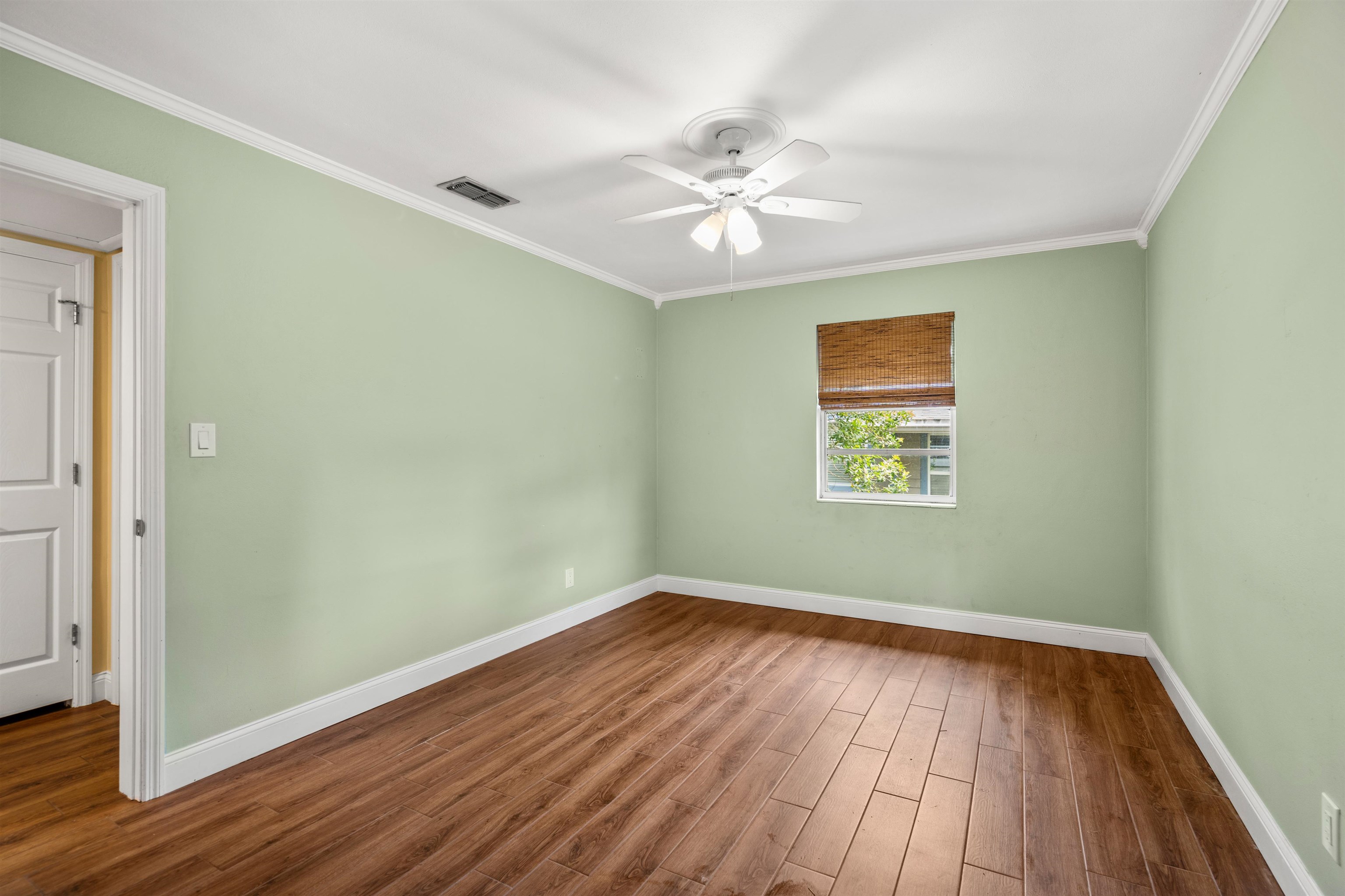146 Menendez Road St. Augustine, FL 32080 - Photo 25 of 39 an empty room with wooden floor fan and windows