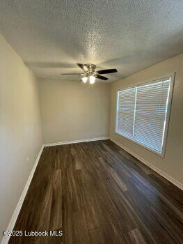 4315 41st Street Lubbock, TX 79413 - Photo 2 of 14 an empty room with wooden floor fan and windows