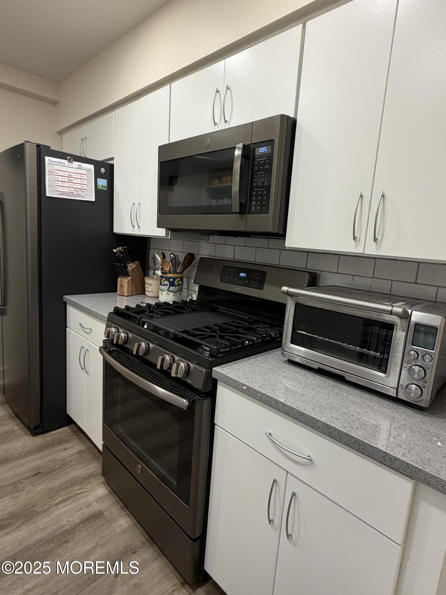 23 Locust Way Spring Lake Heights, NJ 07762 - Photo 14 of 57 a kitchen with stainless steel appliances a stove a microwave and cabinets