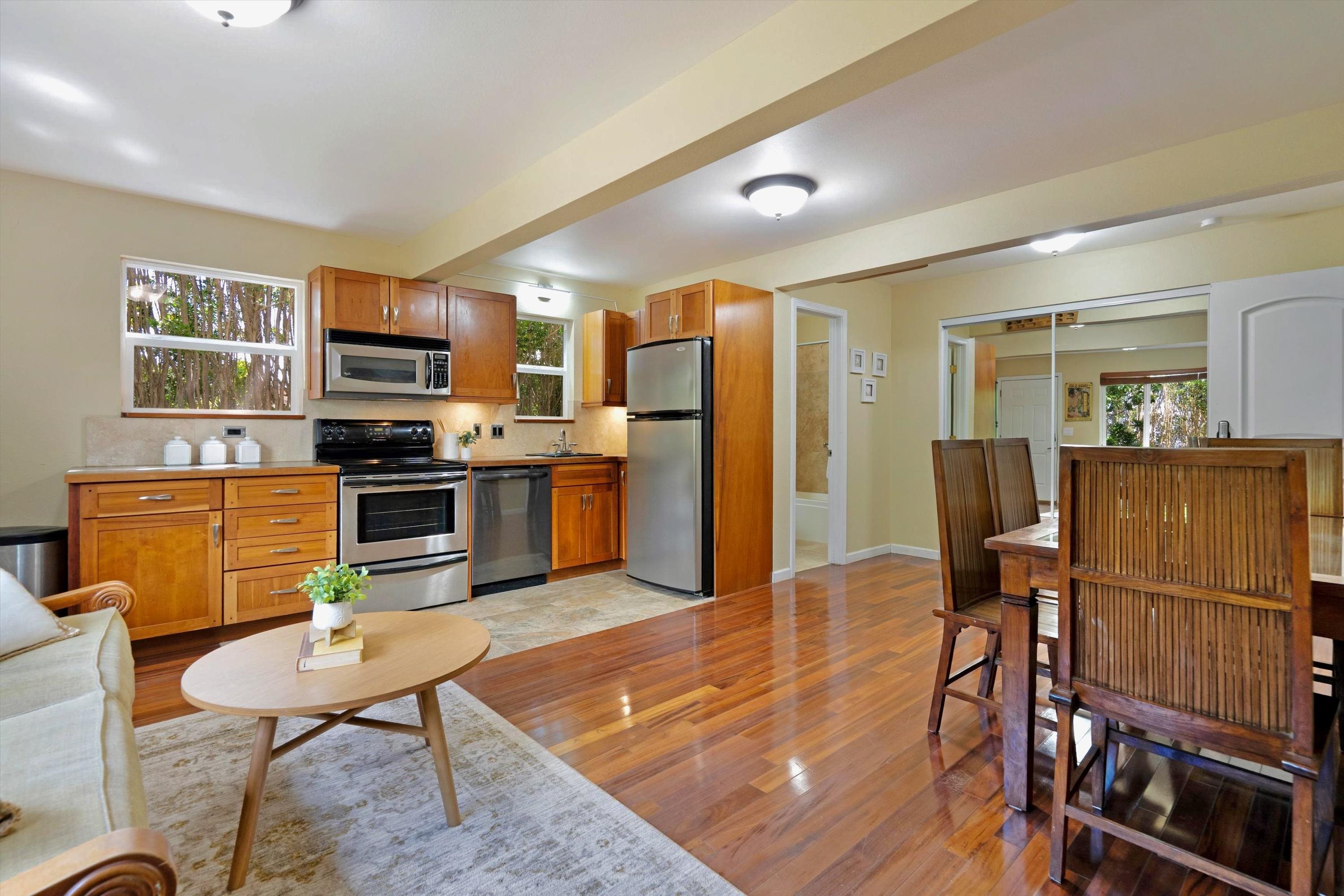 1115 Pookela Road Makawao, HI 96768 - Photo 28 of 37 a kitchen with stainless steel appliances granite countertop a refrigerator a stove top oven a sink dishwasher and wooden cabinets with wooden floor