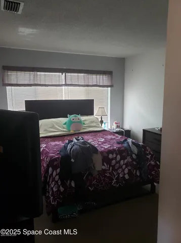 a bed sitting in a bedroom next to a lamp