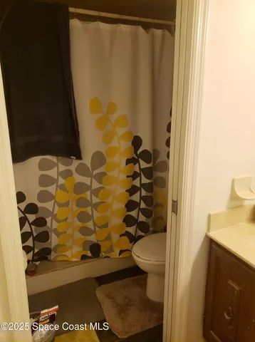 a bathroom with a toilet and a shower curtain