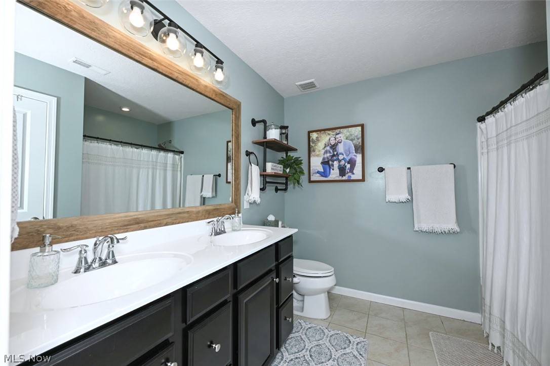 3021 Stonehurst Road Uniontown, OH 44685 - Photo 25 of 48 *ENSUITE FULL MASTER BATHROOM W/TUB & SHOWER, HIS AND HER VANITY & SINKS, 5 SCONCE UPDATED LIGHTING AND CUSTOM WOOD MIRROR SURROUND ~