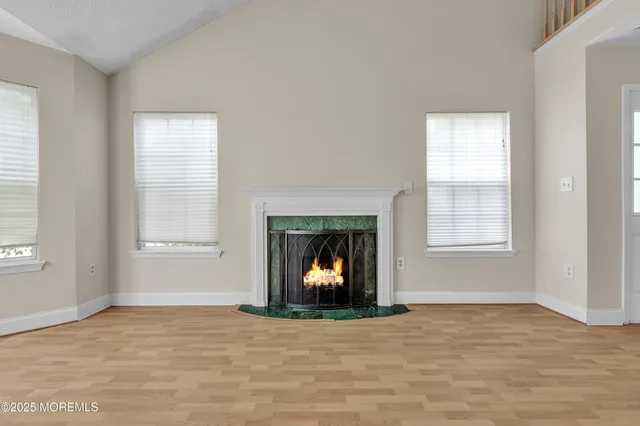 a view of an empty room with window and fire place