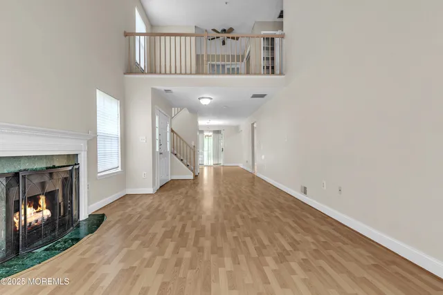 a view of a livingroom with wooden floor and a fireplace