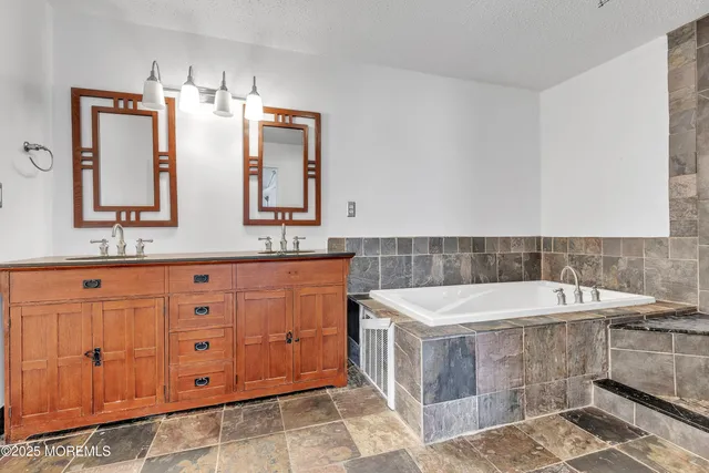 a bathroom with a bathtub sink and mirror