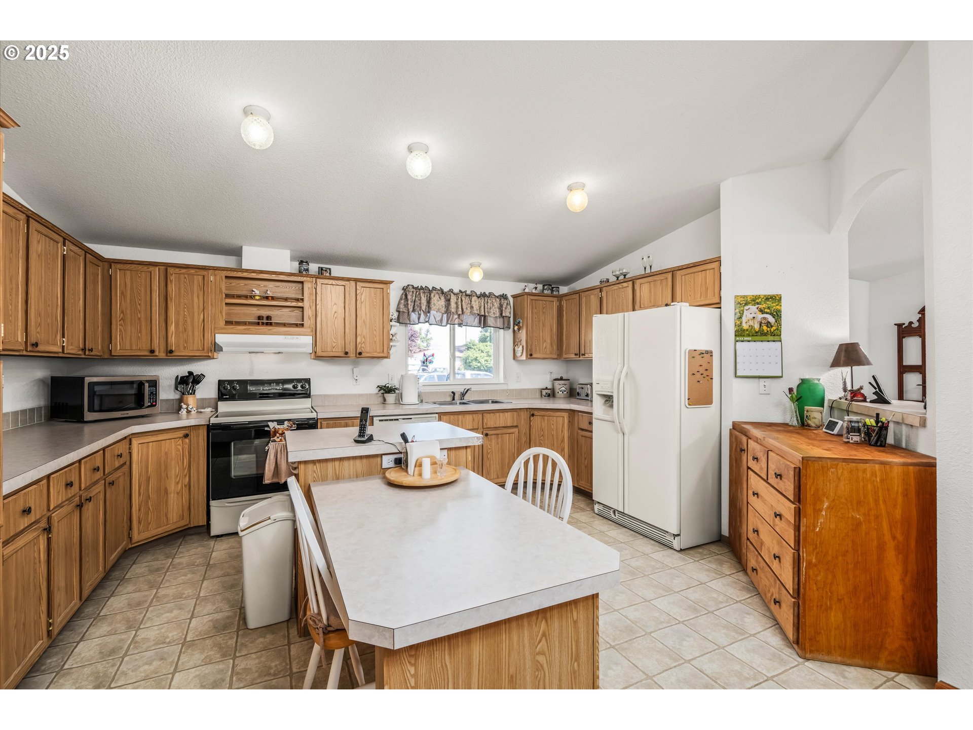2668 Maia Loop Springfield, OR 97477 - Photo 12 of 28 a kitchen with stainless steel appliances granite countertop a refrigerator a stove top oven a sink dishwasher and white cabinets with wooden floor