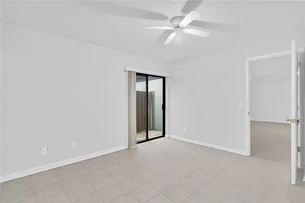 an empty room with a ceiling fan and a window