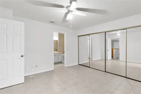 an empty room with fan and glass door