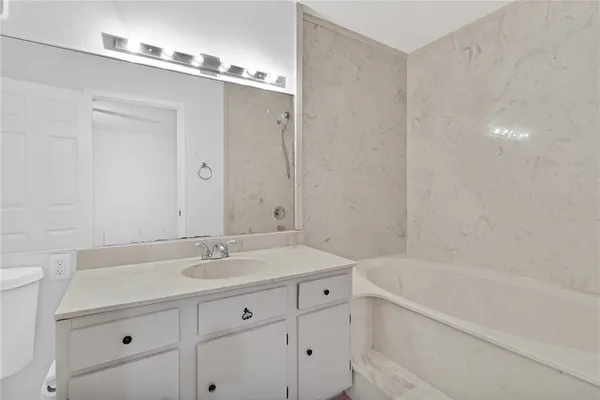 a bathroom with a granite countertop sink a toilet and bathtub