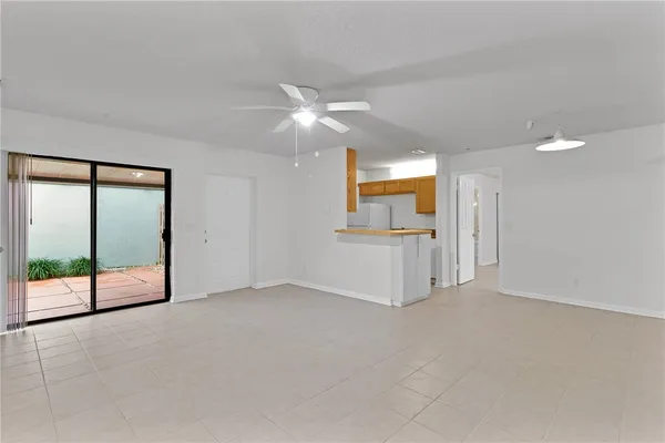 an empty room with fan and windows