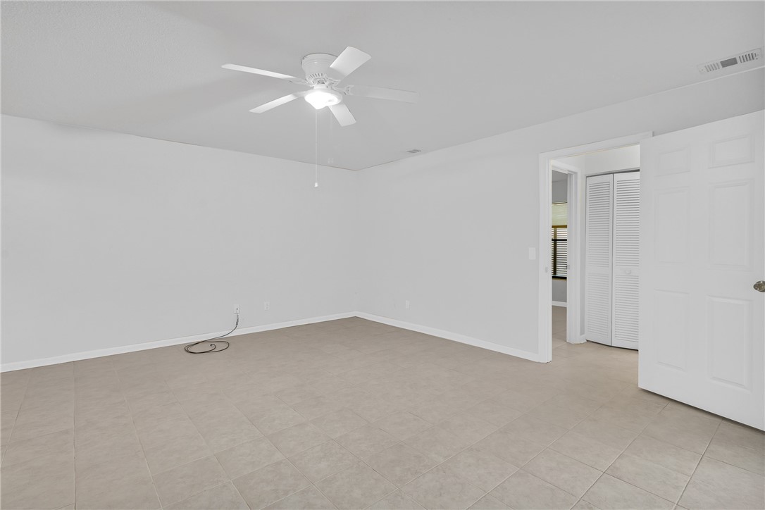 1136 Breezy Way, Unit 3B Sebastian, FL 32958 - Photo 7 of 34 an empty room with a ceiling fan and a window