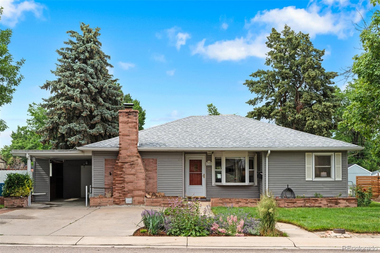 6755 West 45th Avenue Wheat Ridge, CO 80033 - Photo 1 of 27 a front view of a house with garden