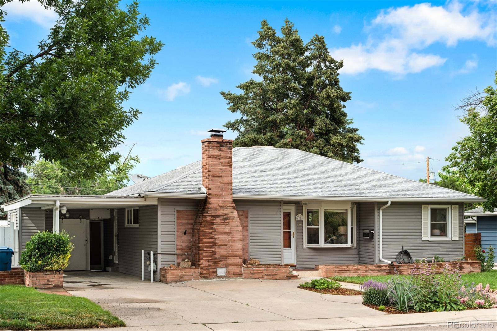 6755 West 45th Avenue Wheat Ridge, CO 80033 - Photo 2 of 27 a front view of a house with garden
