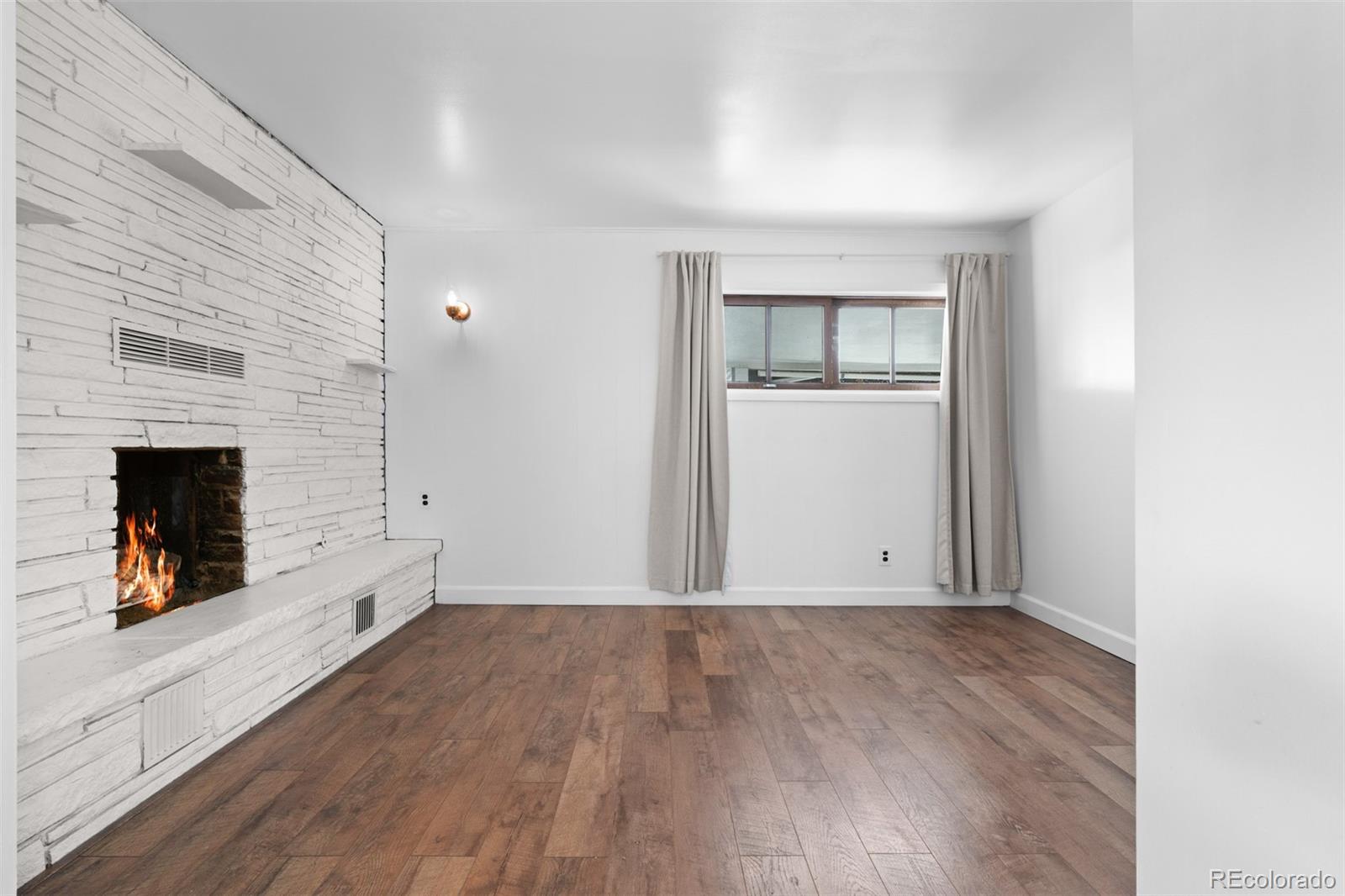 6755 West 45th Avenue Wheat Ridge, CO 80033 - Photo 8 of 27 an empty room with wooden floor and fireplace
