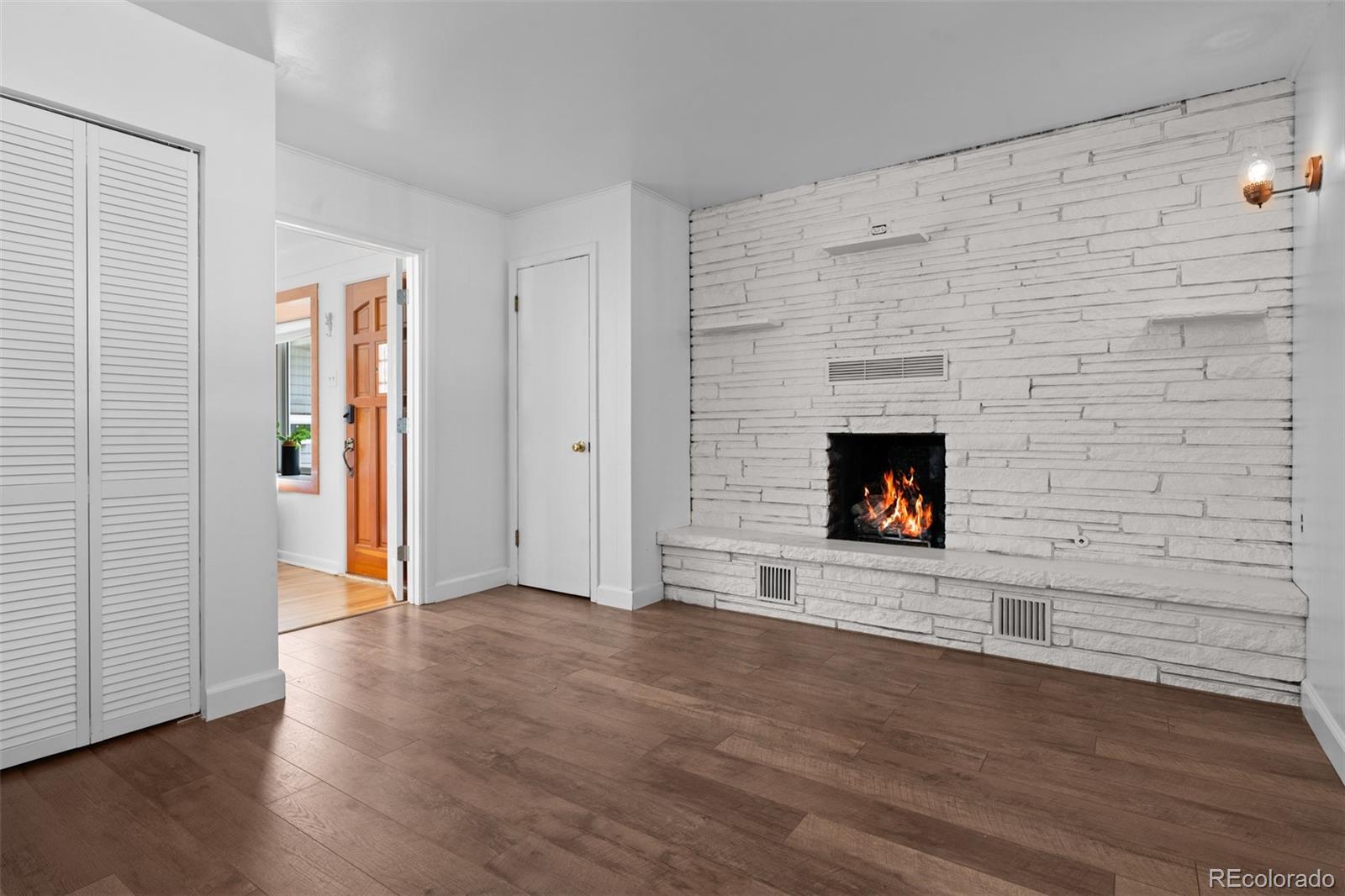 6755 West 45th Avenue Wheat Ridge, CO 80033 - Photo 9 of 27 a view of an empty room with wooden floor and a fireplace