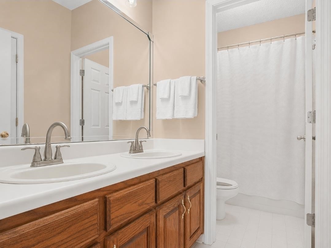 3779 Dancyville Road Stanton, TN 38069 - Photo 8 of 22 Dual vanity with wood-finish cabinetry, white countertops, and brushed nickel fixtures