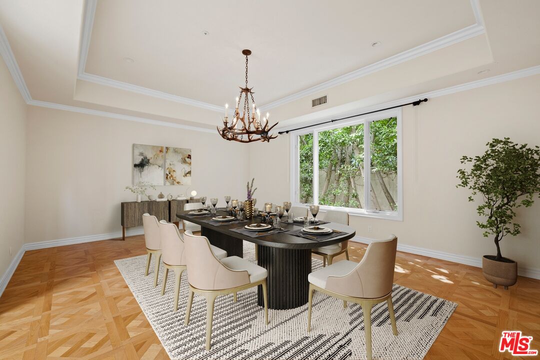 625 Foothill Road Beverly Hills, CA 90210 - Photo 6 of 22 a dining room with wooden floor a chandelier a wooden table and chairs