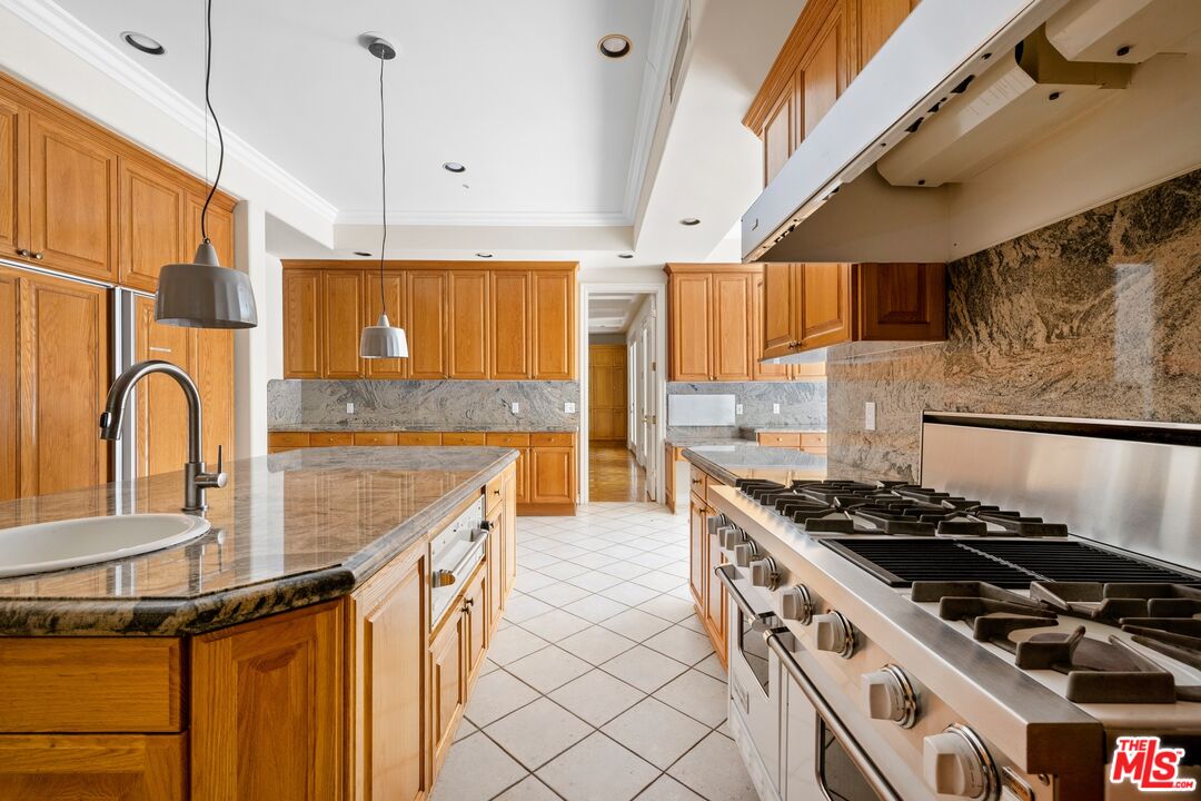 625 Foothill Road Beverly Hills, CA 90210 - Photo 7 of 22 a kitchen with granite countertop a stove and a sink