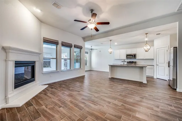 a view of an empty room with a kitchen and a kitchen view