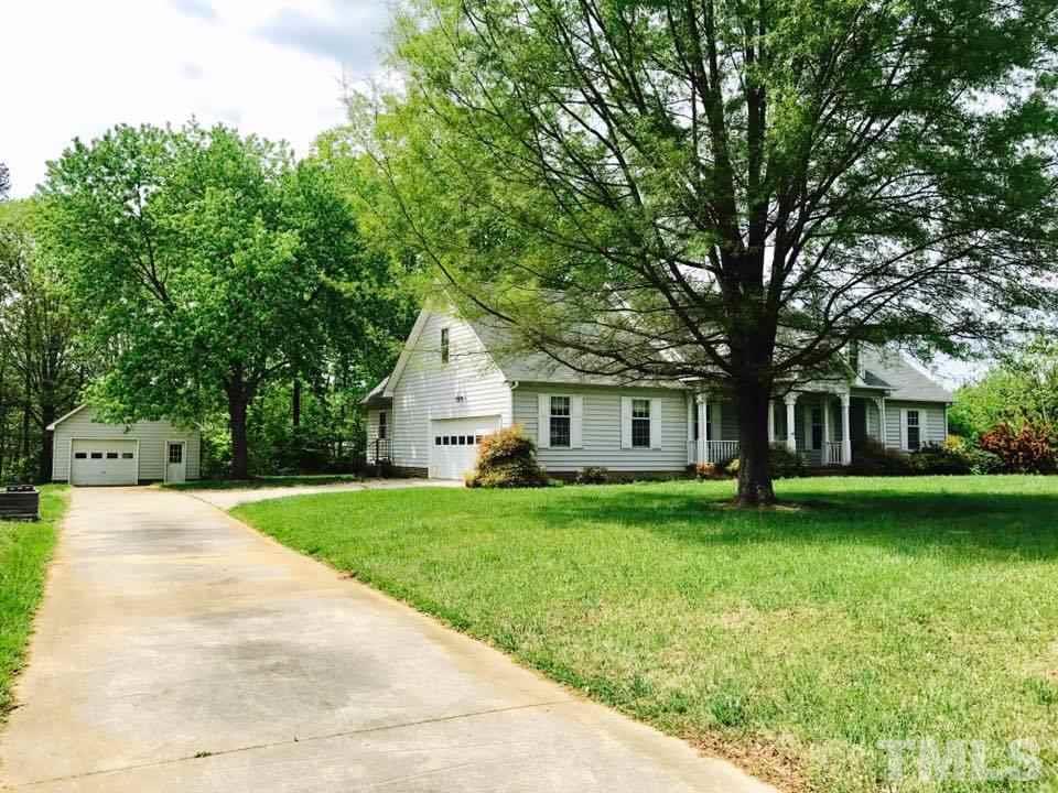 144 Ruff Davis Road Roxboro, NC 27574 - Photo 3 of 16 a front view of a house with a garden and trees