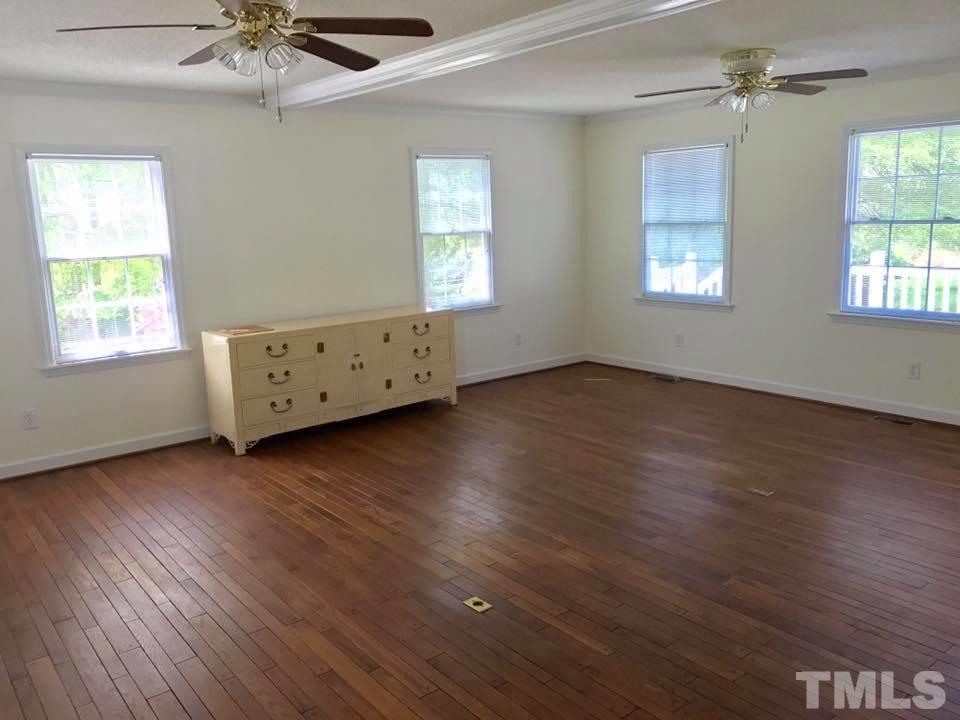 144 Ruff Davis Road Roxboro, NC 27574 - Photo 4 of 16 an empty room with wooden floor windows and fan