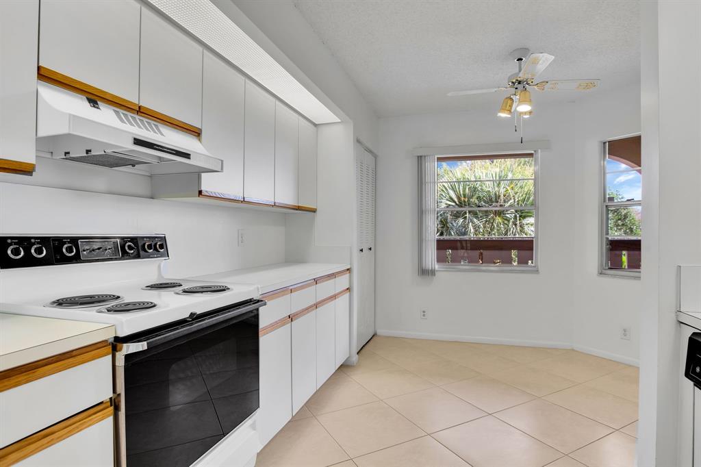 1601 Abaco Drive, Unit D4 Coconut Creek, FL 33066 - Photo 2 of 30 a kitchen with stainless steel appliances granite countertop a sink stove and cabinets