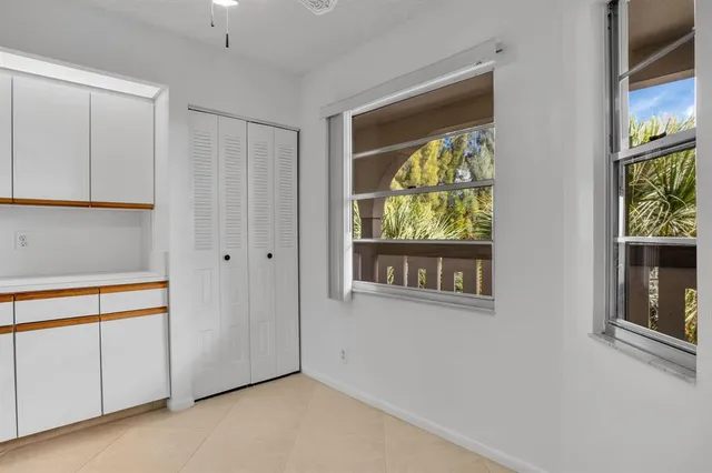 a view of an empty room with window and cabinet