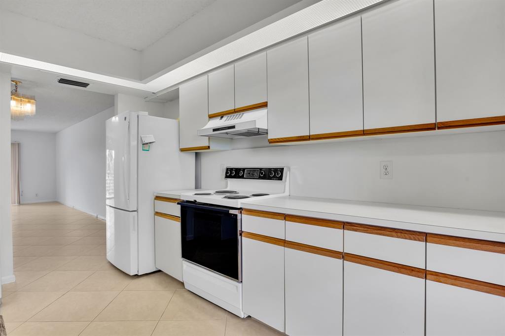 1601 Abaco Drive, Unit D4 Coconut Creek, FL 33066 - Photo 5 of 30 a kitchen with stainless steel appliances granite countertop a refrigerator and a stove