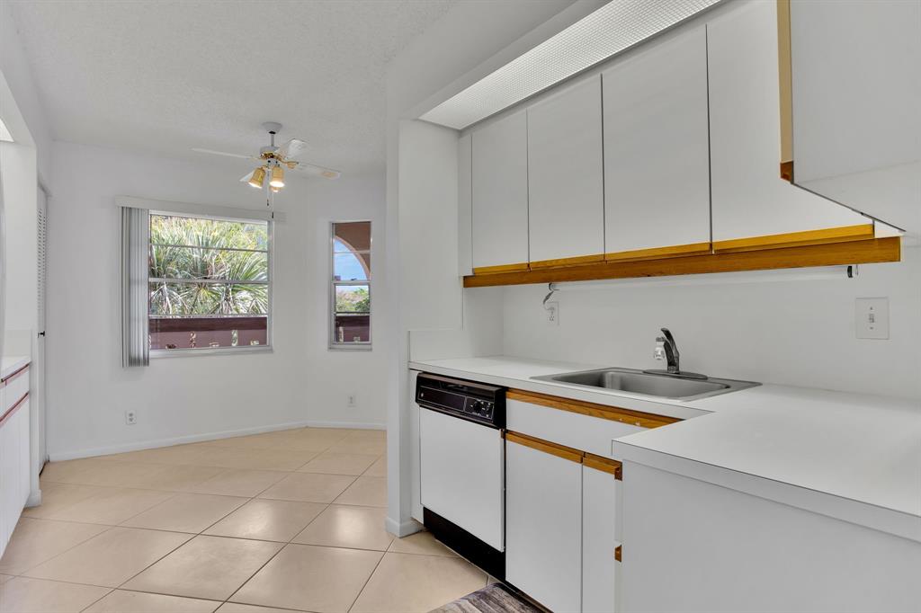 1601 Abaco Drive, Unit D4 Coconut Creek, FL 33066 - Photo 7 of 30 a kitchen with a sink cabinets and a window
