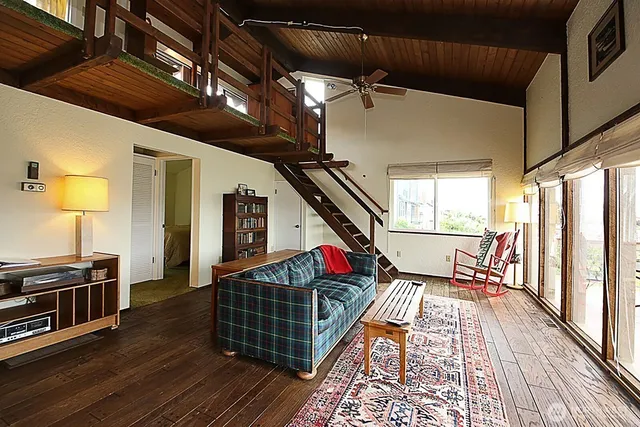 a living room with furniture stove and wooden floor