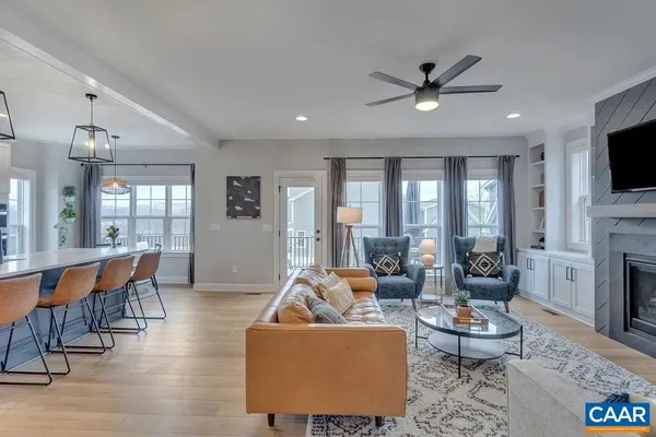 a kitchen with stainless steel appliances kitchen island granite countertop a dining table chairs and white cabinets
