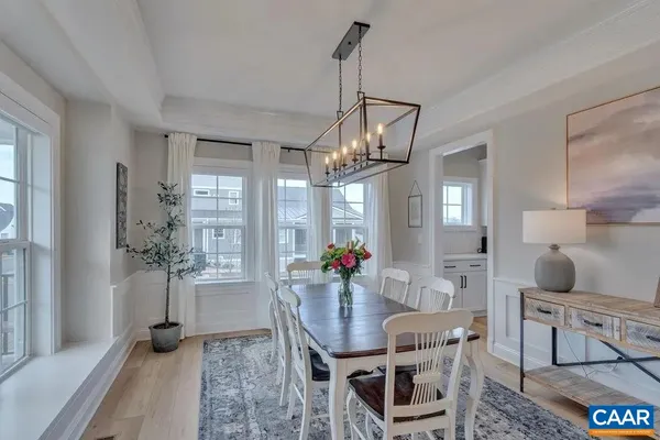 a kitchen with stainless steel appliances granite countertop a sink a stove a refrigerator cabinets and chairs