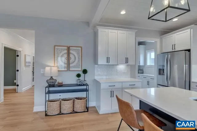 a kitchen with stainless steel appliances granite countertop a sink refrigerator dining table and chairs