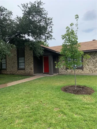 a house is sitting in middle od the grass
