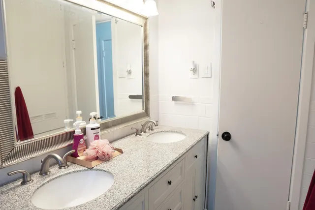 a bathroom with a granite countertop sink and a mirror