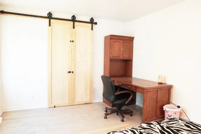 a view of a workspace with furniture and a window