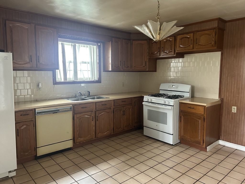 69 Mott Street Fall River, MA 02721 - Photo 8 of 31 a kitchen with a stove sink and cabinets