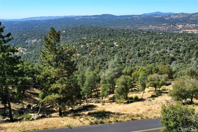 an aerial view of a houses with a lush green hillside