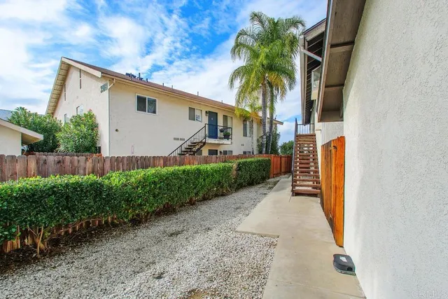 a view of a house with a yard and potted plants