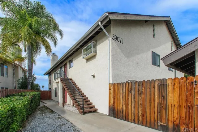 a view of a house with wooden fence