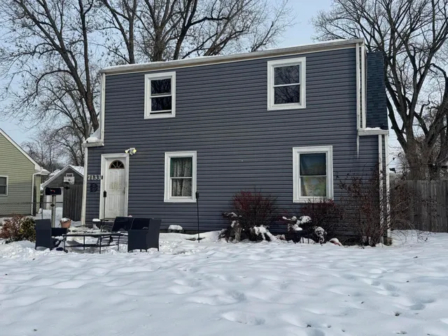 a view of a house with a yard covered in snow