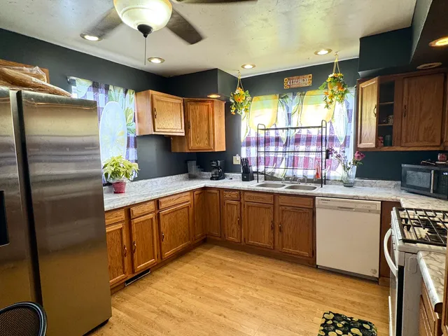 a kitchen with stainless steel appliances granite countertop a sink window and cabinets