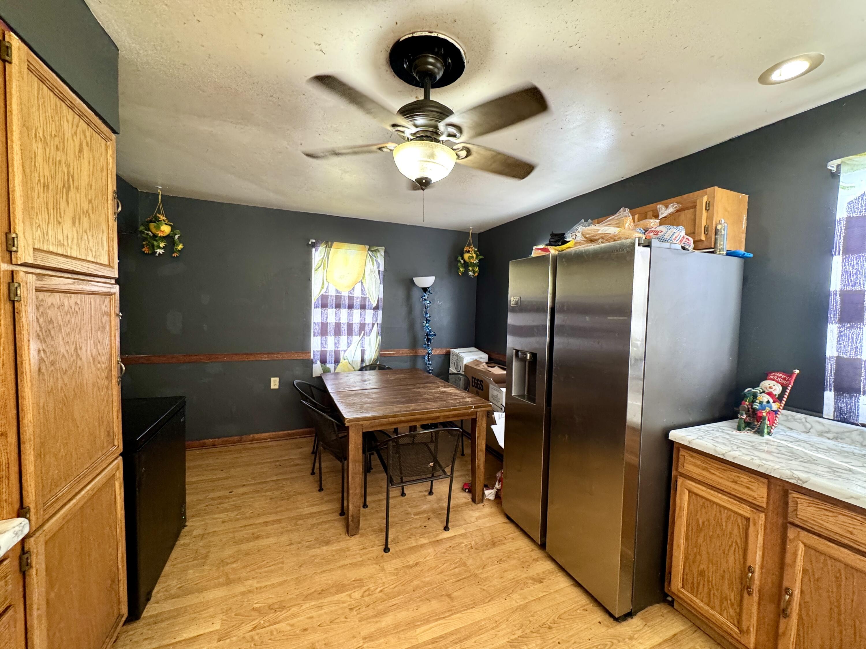 7133 Kentucky Avenue Hammond, IN 46323 - Photo 7 of 27 a kitchen with stainless steel appliances kitchen island granite countertop a refrigerator a stove a sink dishwasher and a dining table with wooden floor