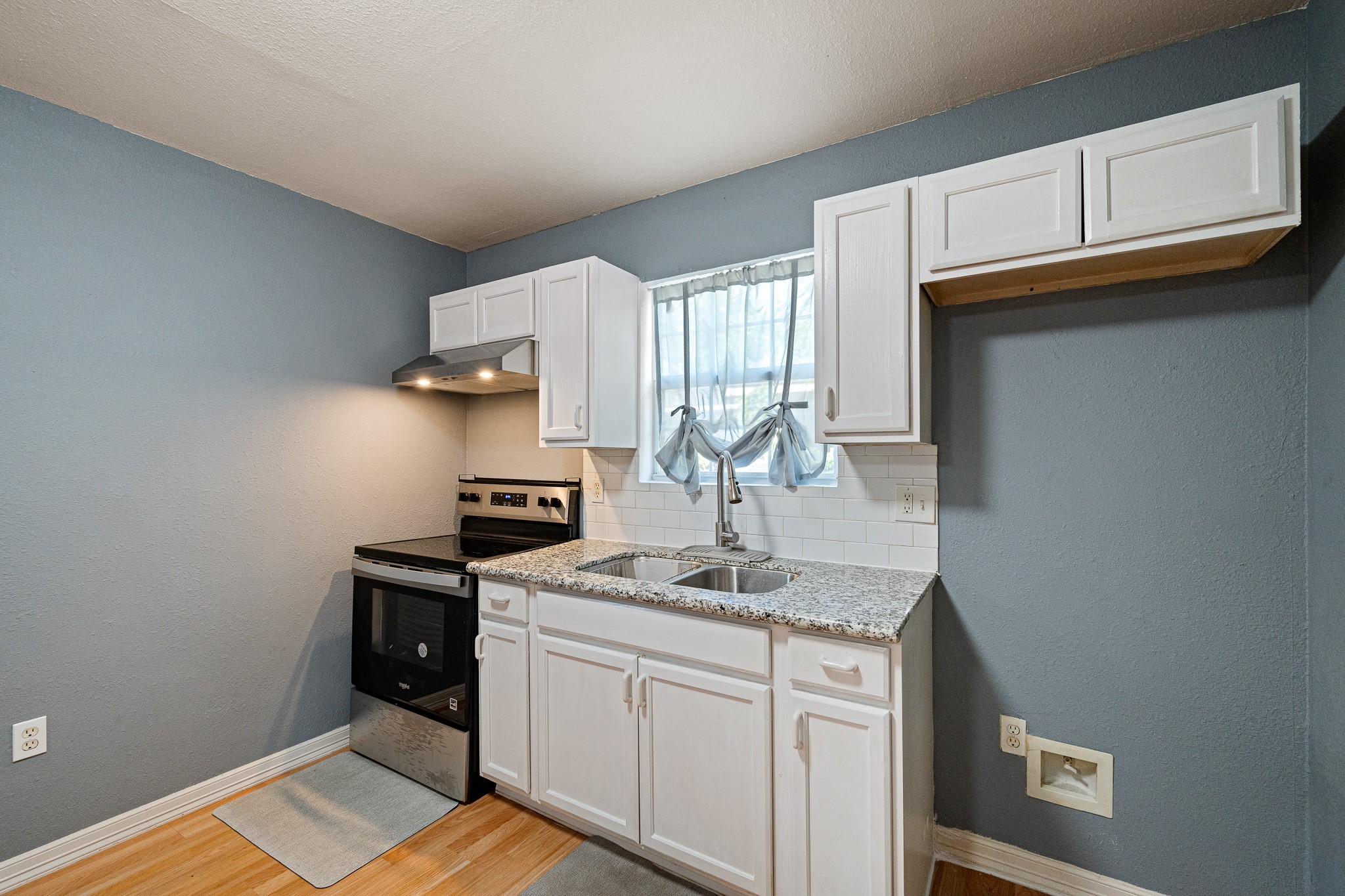 7815 Harding Street, Unit B Houston, TX 77012 - Photo 12 of 21 This cozy kitchen features sleek, modern appliances, elegant white cabinetry, and a charming window that bathes the space in natural light, perfect for culinary creativity.