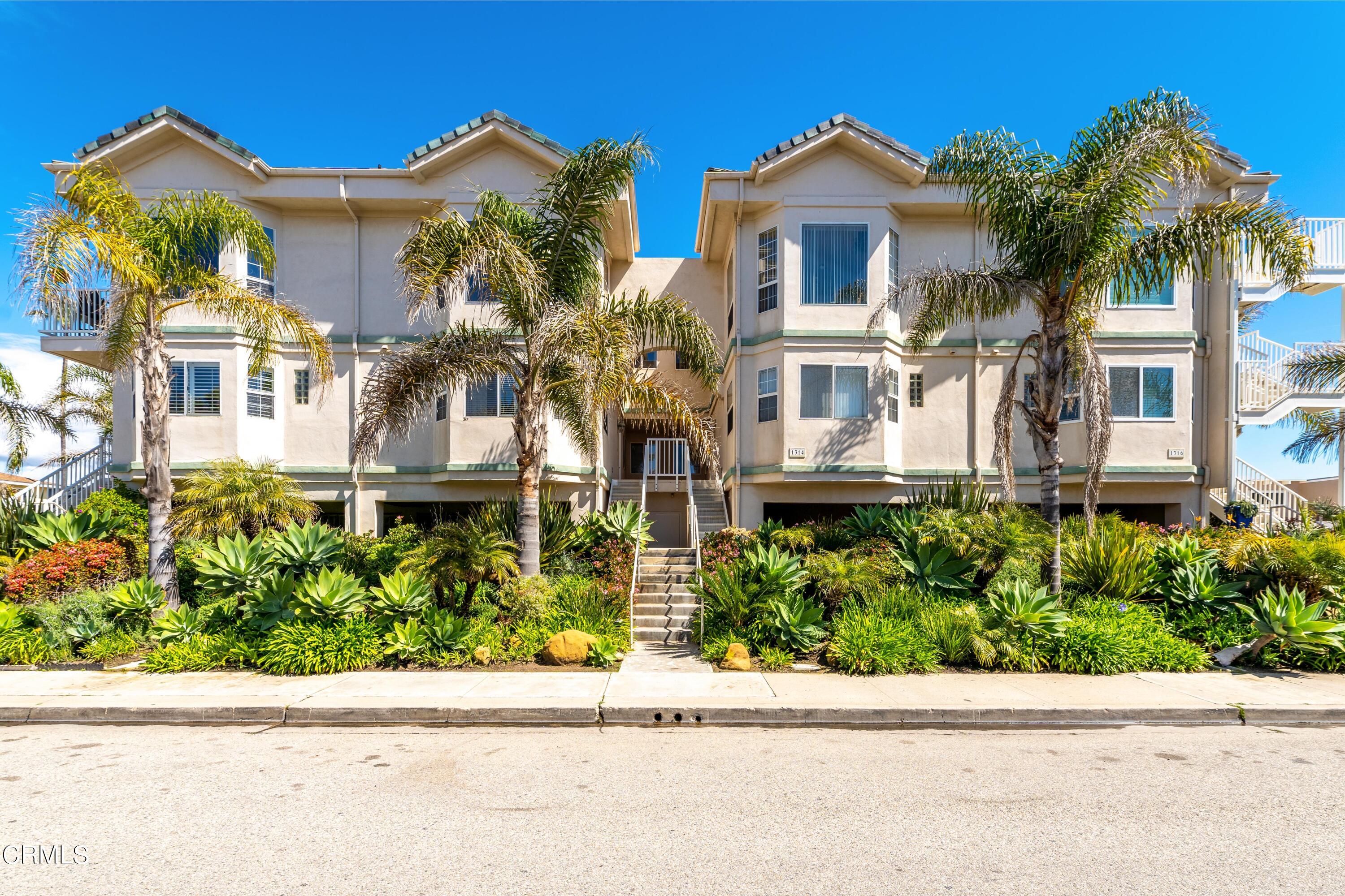 front view of house with a yard and potted plants